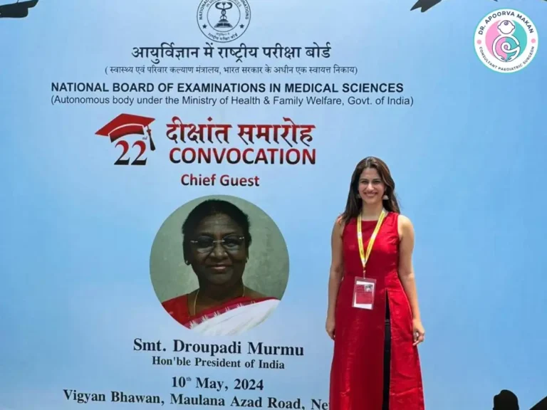 Dr. Apoorva Makan posing in front of convocation ceremony hoarding having president's photo.