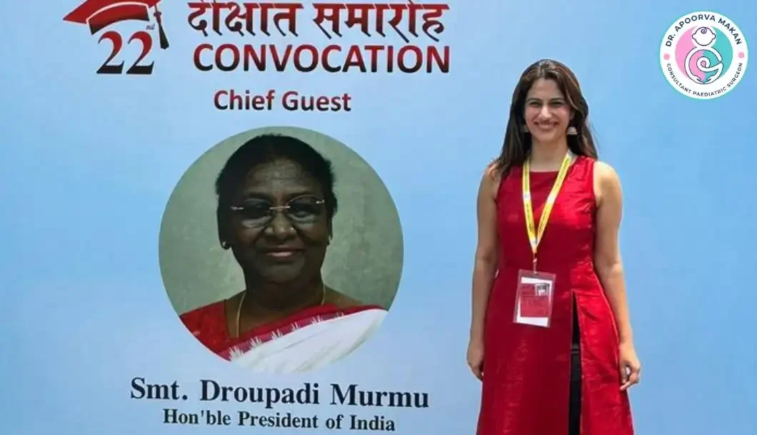 Dr. Apoorva Makan standing in front of hoarding at convocation ceremony in Delhi.