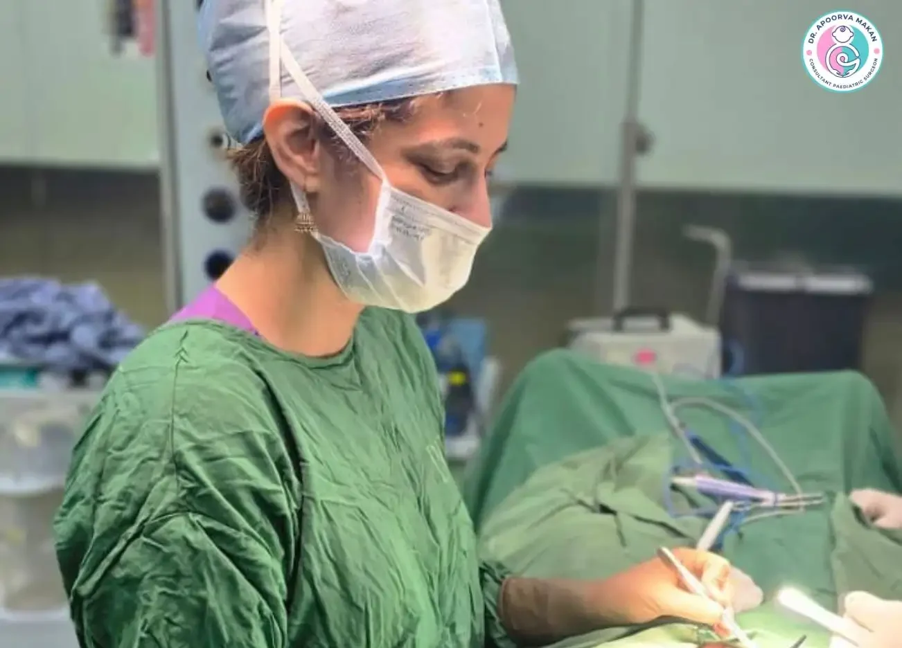 Dr. Apoorva Makan wearing surgical mask doing child hernia surgery.